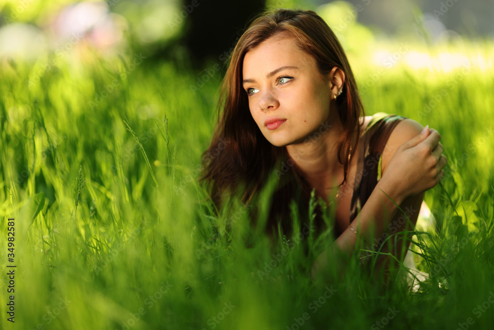 brunette lying on green grass brunette lying on green grass