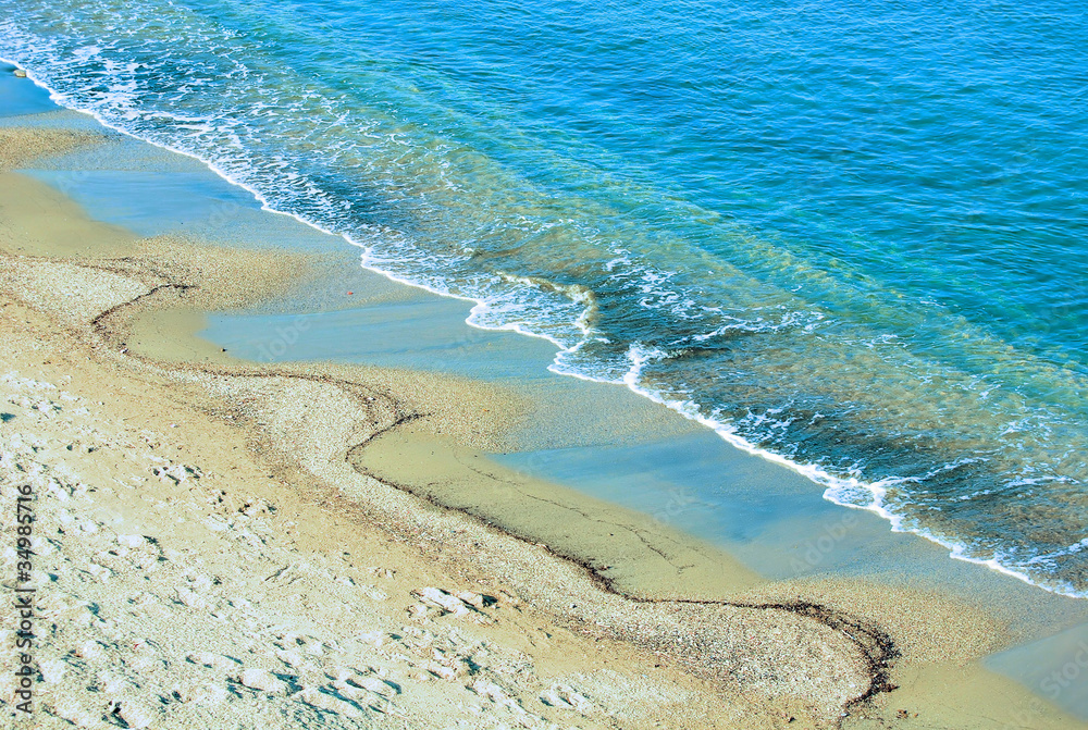 sand on a beach of Mediterranean sea and a turquoise wave