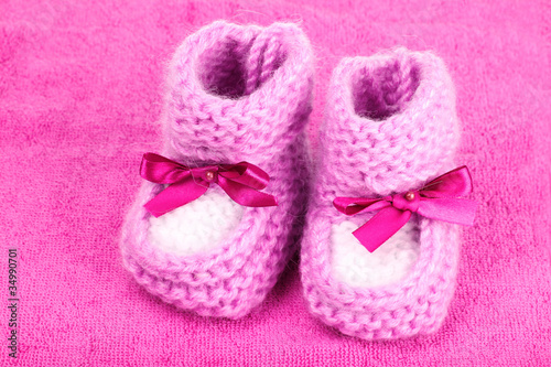 bright baby booties on pink background