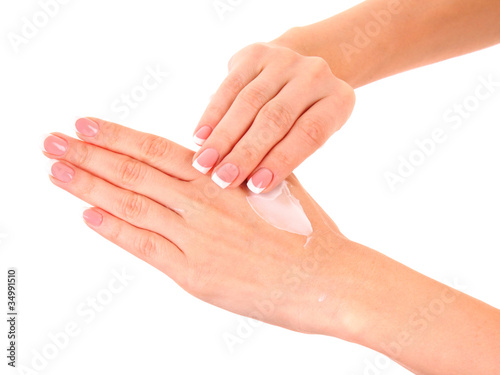 Closeup of beautiful female hands applying hand cream isolated