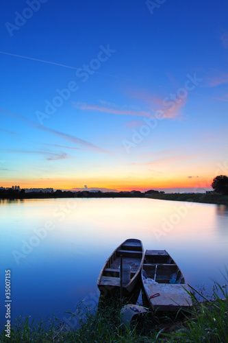 Sunset along the pond with two boats