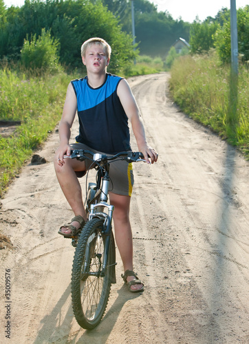 Teenager goes on bicycle on country road