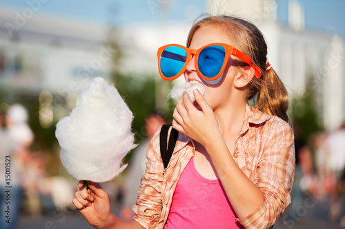 Girl eating cotton candy photo