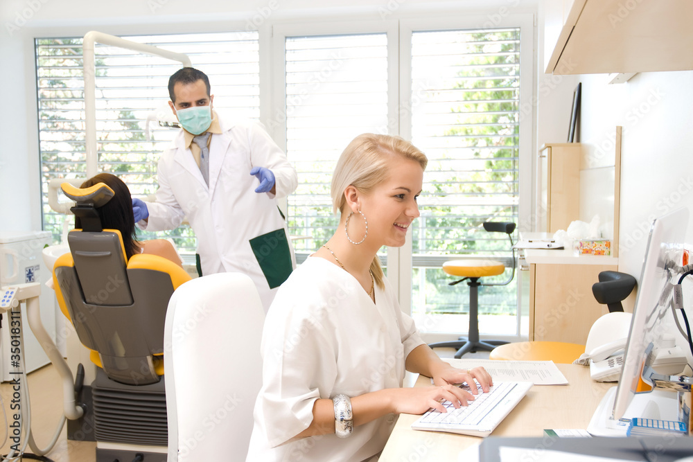 Dental examination, while the assistant is working on a laptop