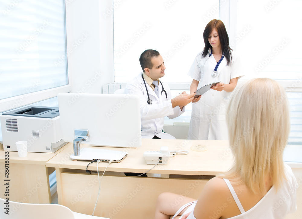 Nurse shows the folder to the doctor, the patient is waiting