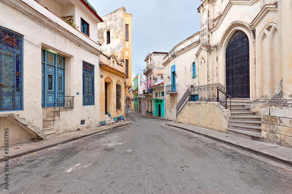 Colorful street in Old Havana sidelined with decaying buildings