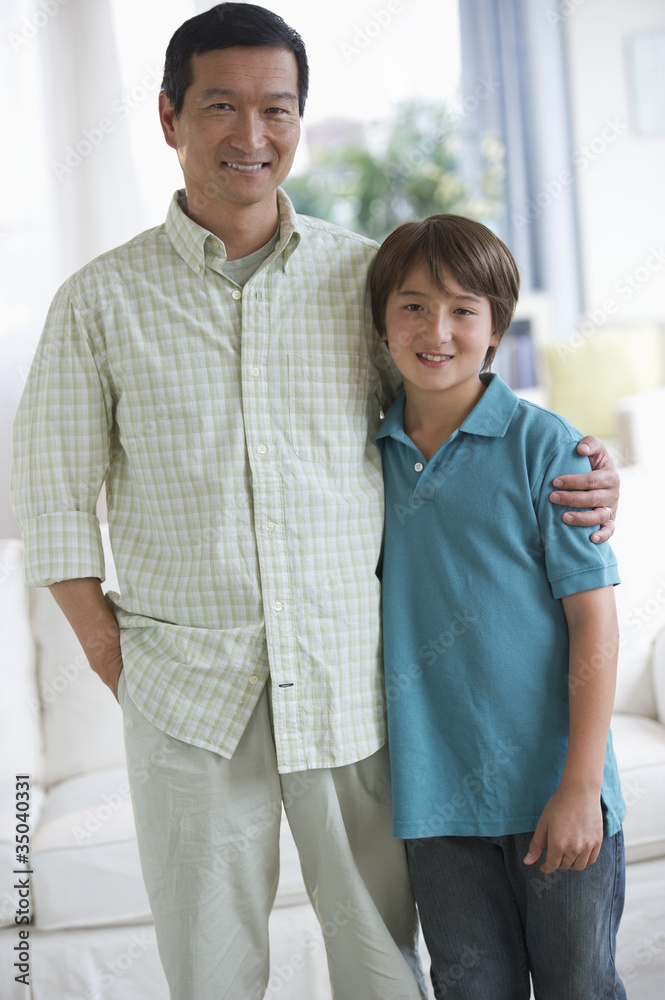 Smiling father and son hugging in living room Smiling father and son hugging in living room
