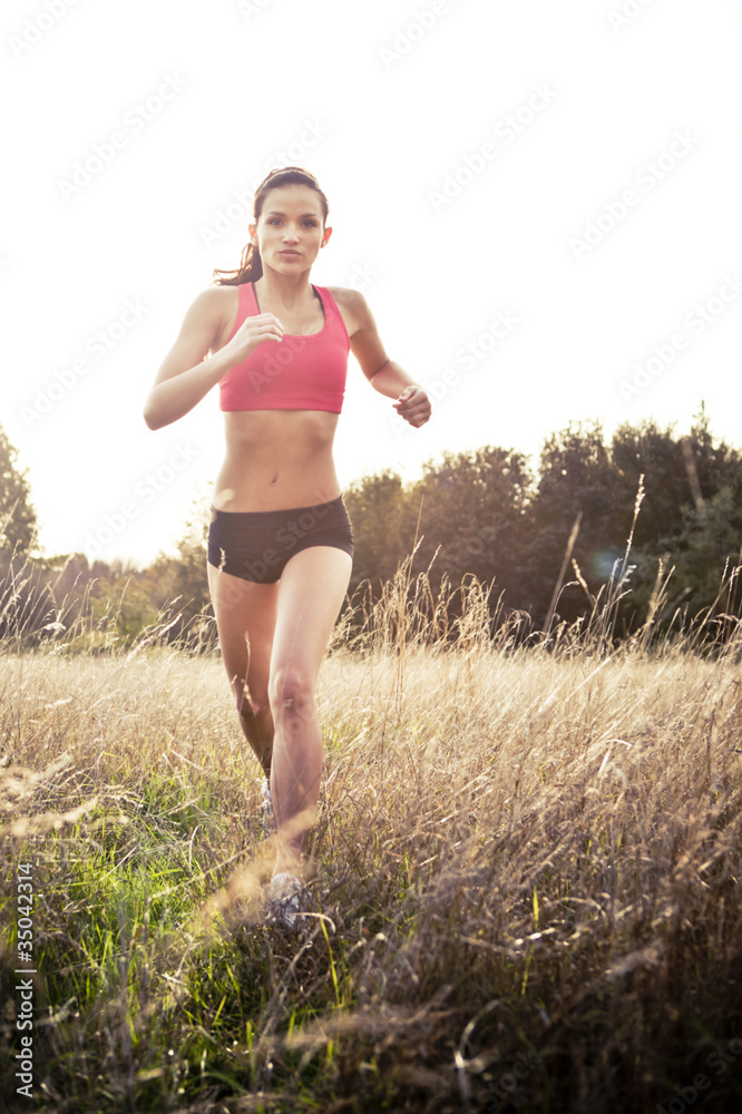 Mixed race jogger running through field Mixed race jogger running through field