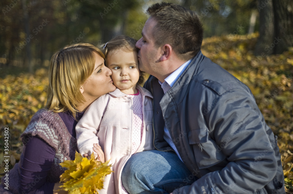 Parents kissing their little girl Parents kissing their little girl