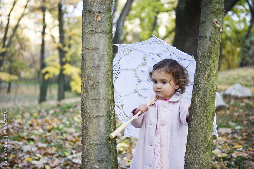 Little girl with umbrella in the park in autumn Little girl with umbrella in the park in autumn