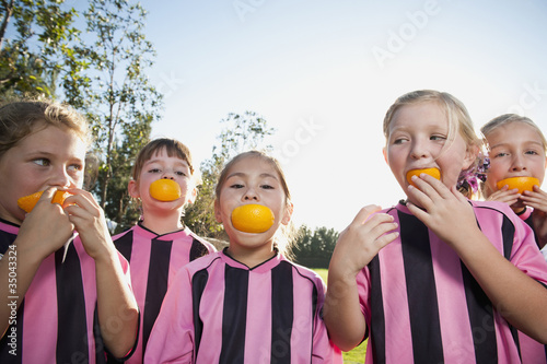 Girl soccer players eating orange slices