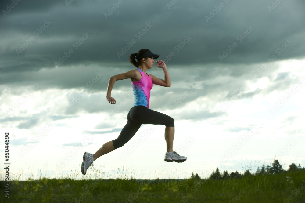 Japanese woman running in field Japanese woman running in field