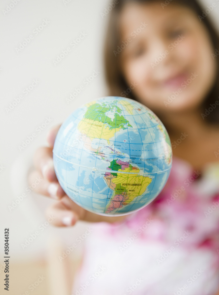 Hispanic girl holding small globe Hispanic girl holding small globe