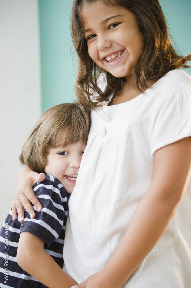 Hispanic girl hugging her brother Hispanic girl hugging her brother