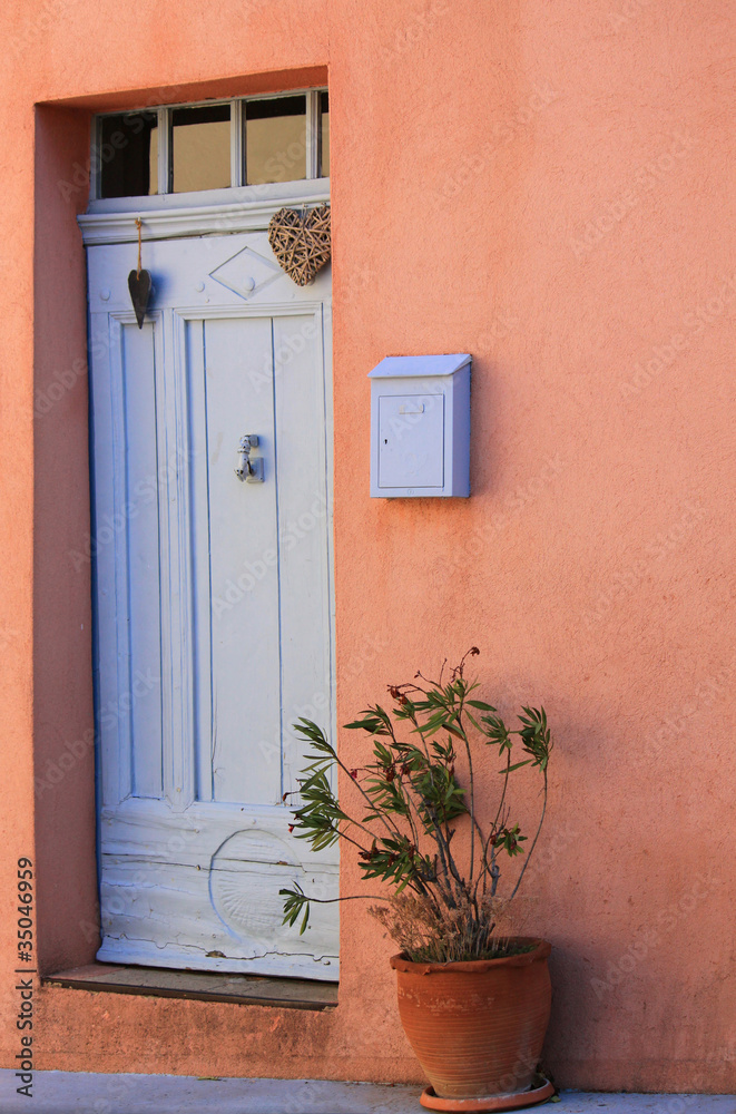 Obraz premium Charmante alte Eingangstür dekoriert mit Herz und einem Oleander im Terracotta Topf in einem Dorf in der Provence, Côte d'Azur