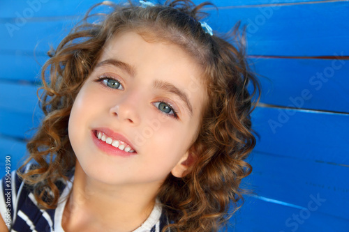 children little girl smiling on wooden blue wall © lunamarina