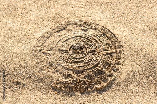 Aztec calendar stone carving on sand photo