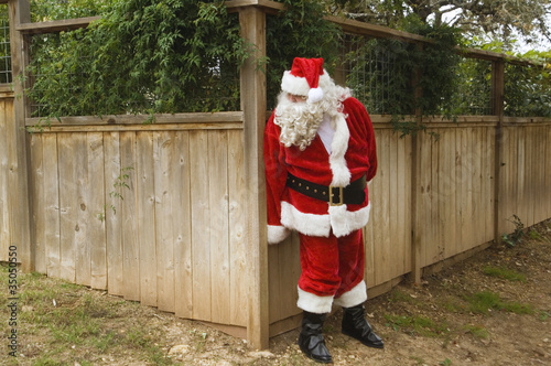 Santa hiding behind fence