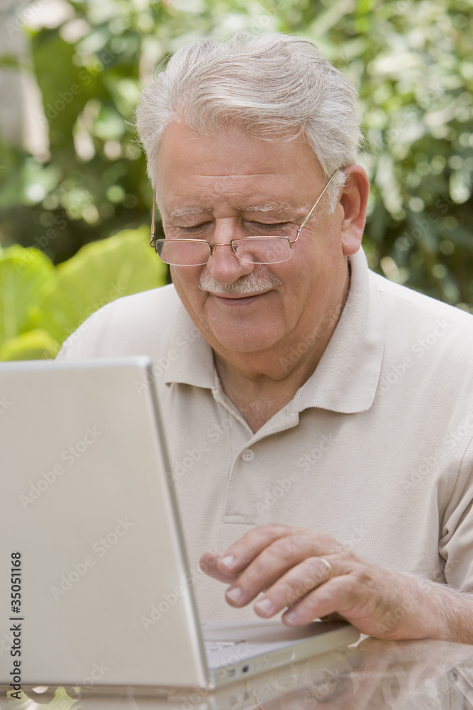 Senior Chilean man typing on laptop Senior Chilean man typing on laptop