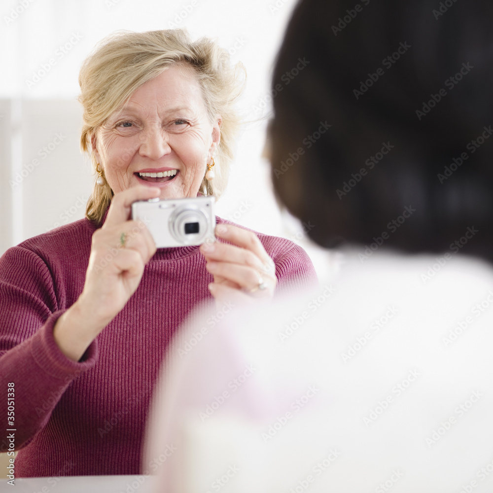 Caucasian woman taking photograph of friend Caucasian woman taking photograph of friend