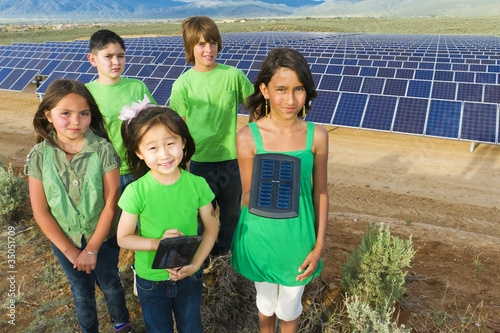Children standing together in solar panel field