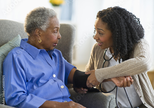 Nurse taking woman’s blood pressure