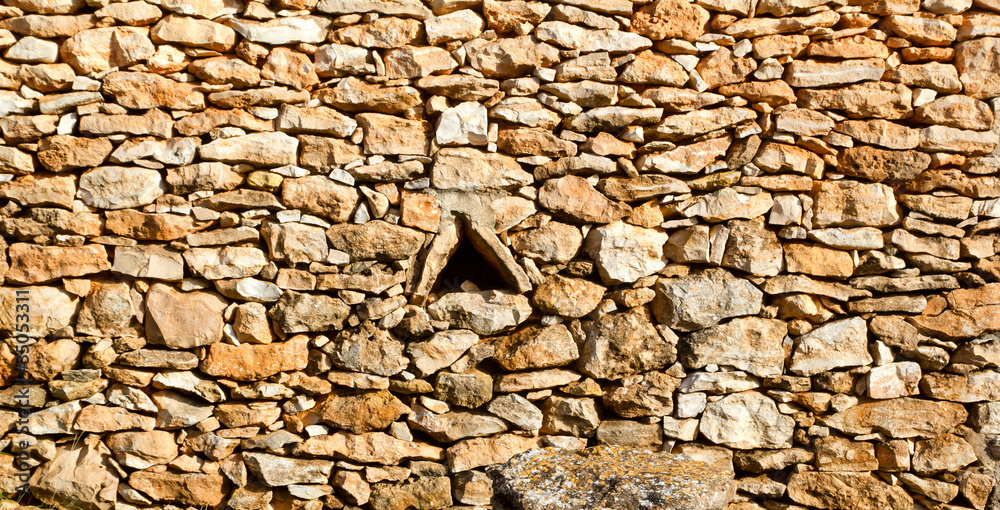 Fototapeta premium aged masonry stone wall triangle window hole