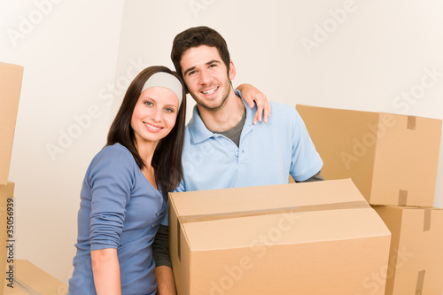 Moving home young couple carrying cardboard boxes © CandyBox Images