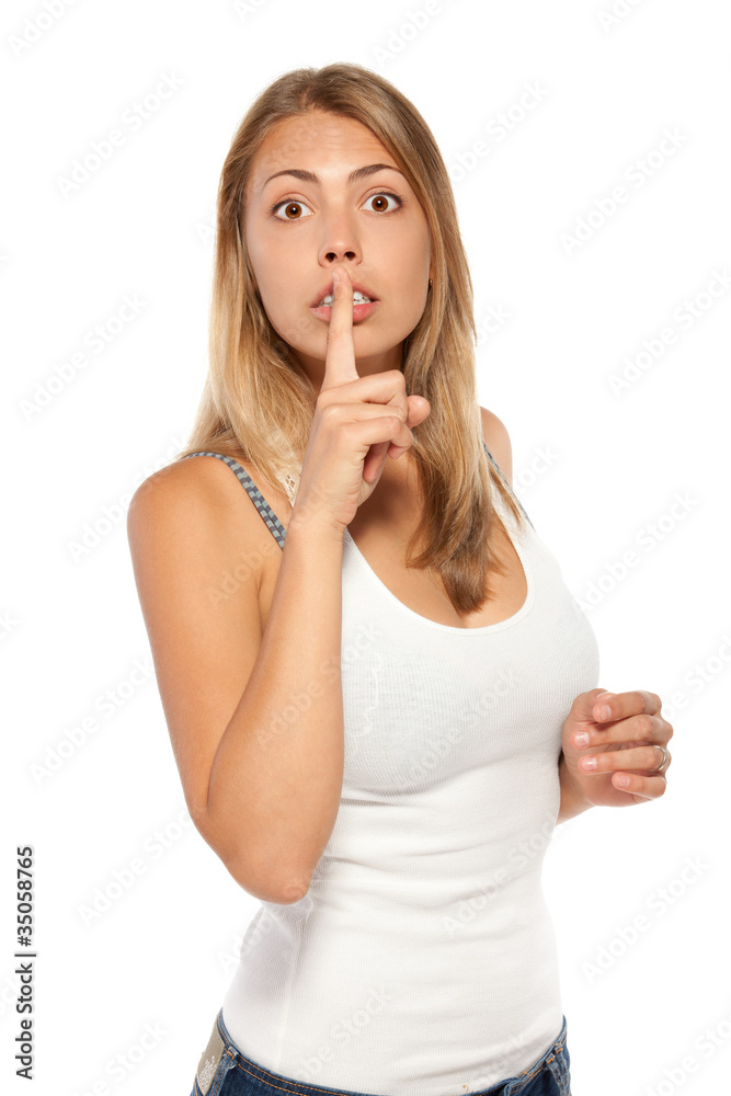 Astonished woman with finger on lips asking to say no evil Astonished woman with finger on lips asking to say no evil
