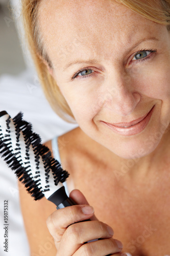 Mid age woman holding hairbrush