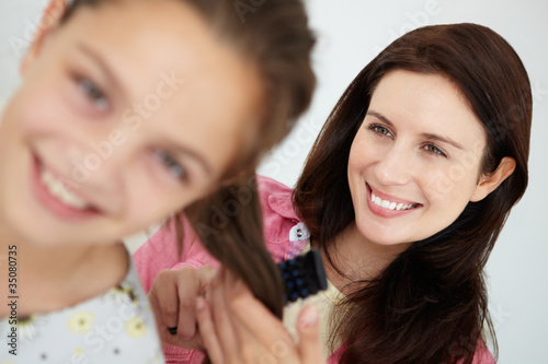 Mother brushing daughter s hair