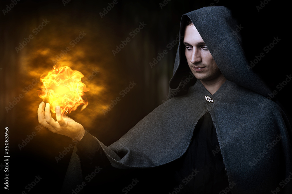 Fototapeta premium Halloween concept. Male wizard with fireball