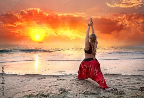 Yoga virabhadrasana warrior pose at sunset photo