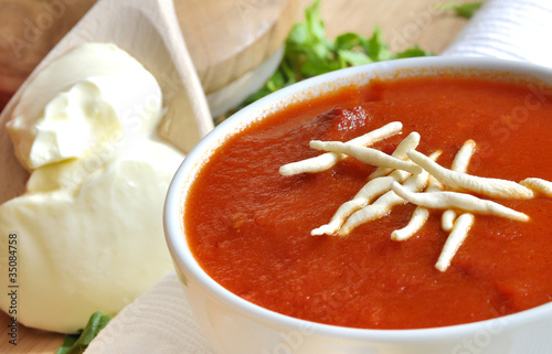 tradycyjna zupa pomidorowa z łyżką gęstej śmietany i pietruszką