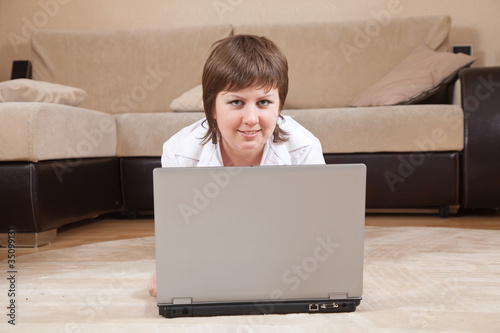 woman lying on floor and using laptop