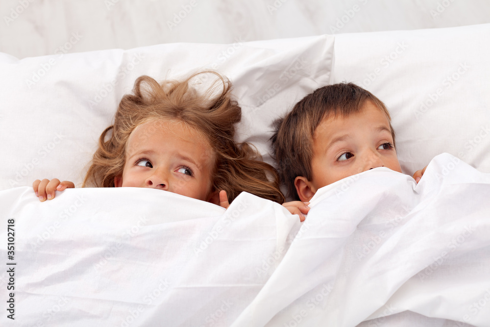 Kids afraid pulling the quilt on their heads Kids afraid pulling the quilt on their heads