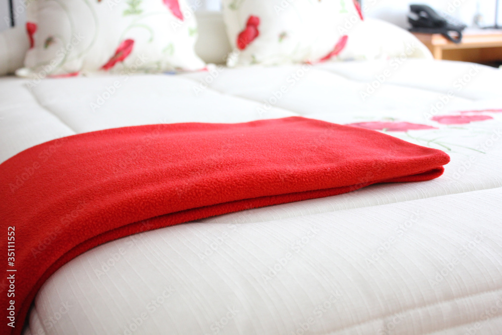 Cama con manta roja Stock Photo | Adobe Stock