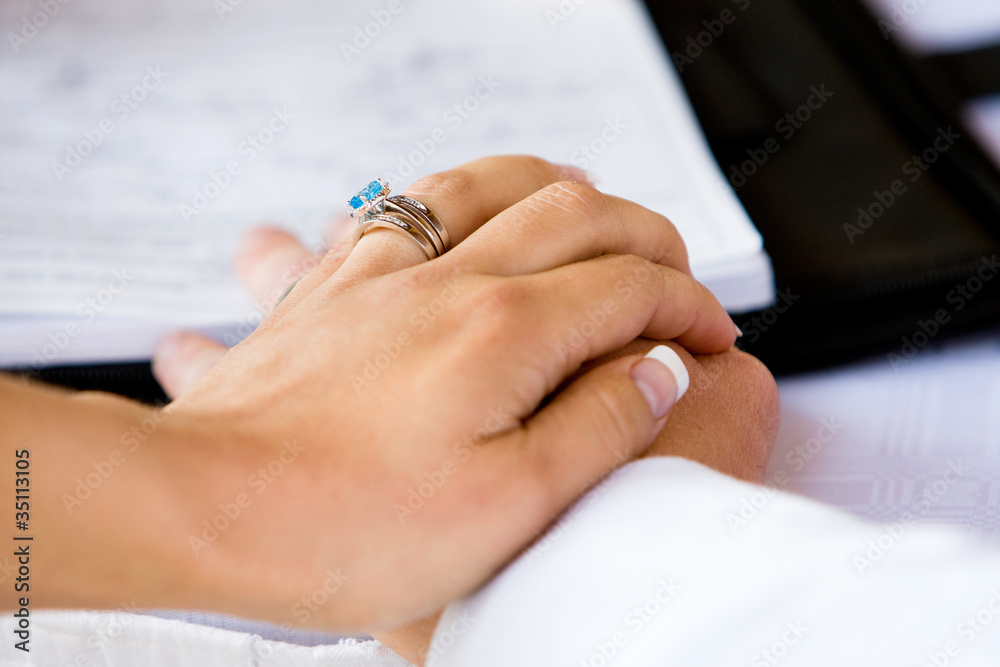 A close up of a bride's hand on the the groom's