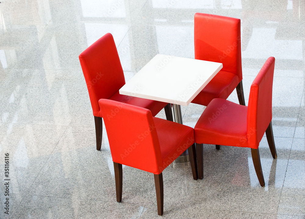 Fototapeta premium four red chairs at a table