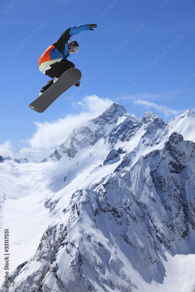 Snowboarder, jump in high mountains