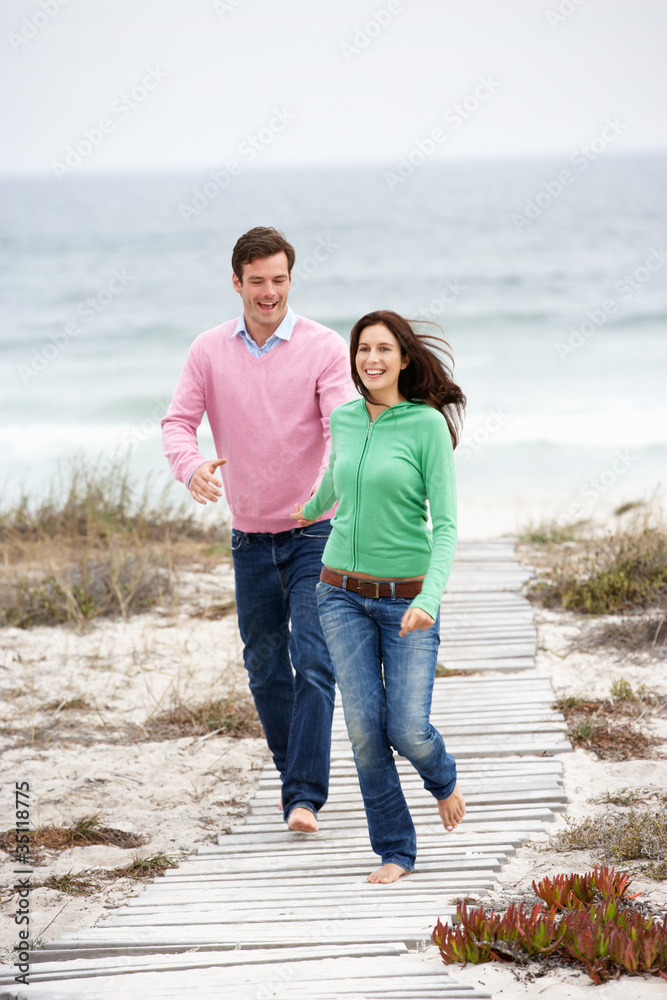 Couple running along beach path
