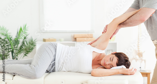 Cuadro en lienzo Chiropractor stretching woman's arm