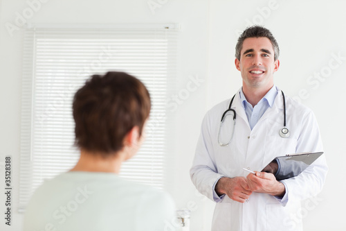 Smiling Doctor talking to a brunette woman