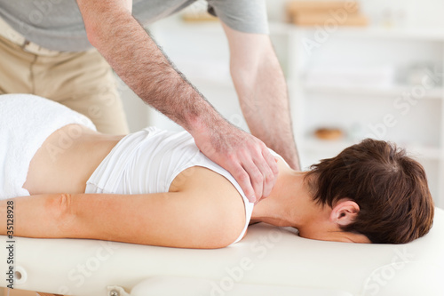 Masseur massaging a woman's neck