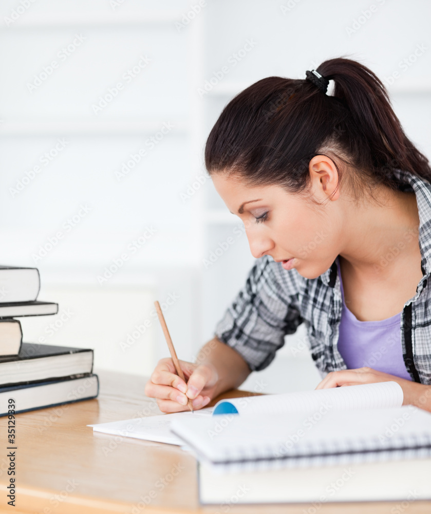 Young student writing in her exrecise book Young student writing in her exrecise book