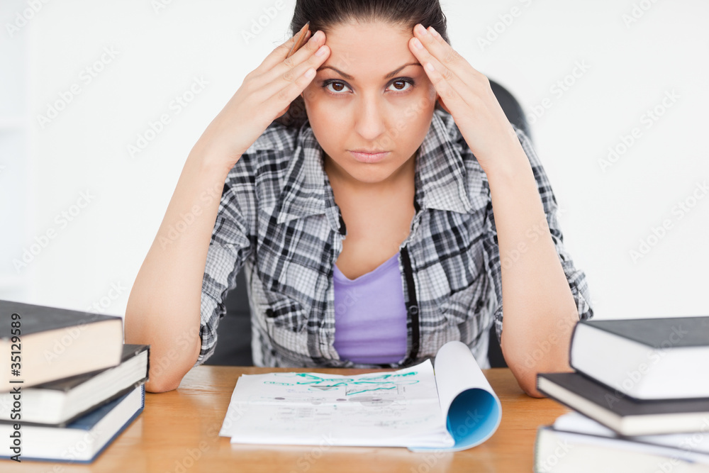Stressed student with homework looking to camera Stressed student with homework looking to camera