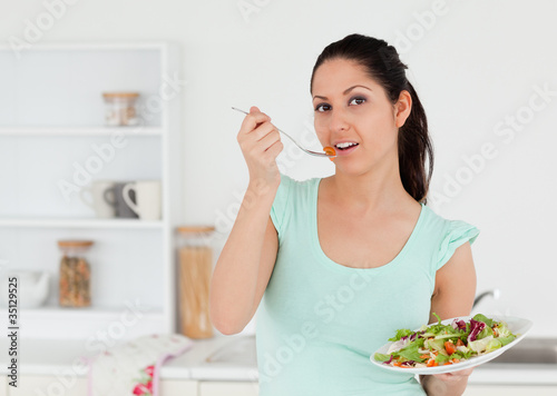 Lovely young woman with salad in kitchen © WavebreakmediaMicro