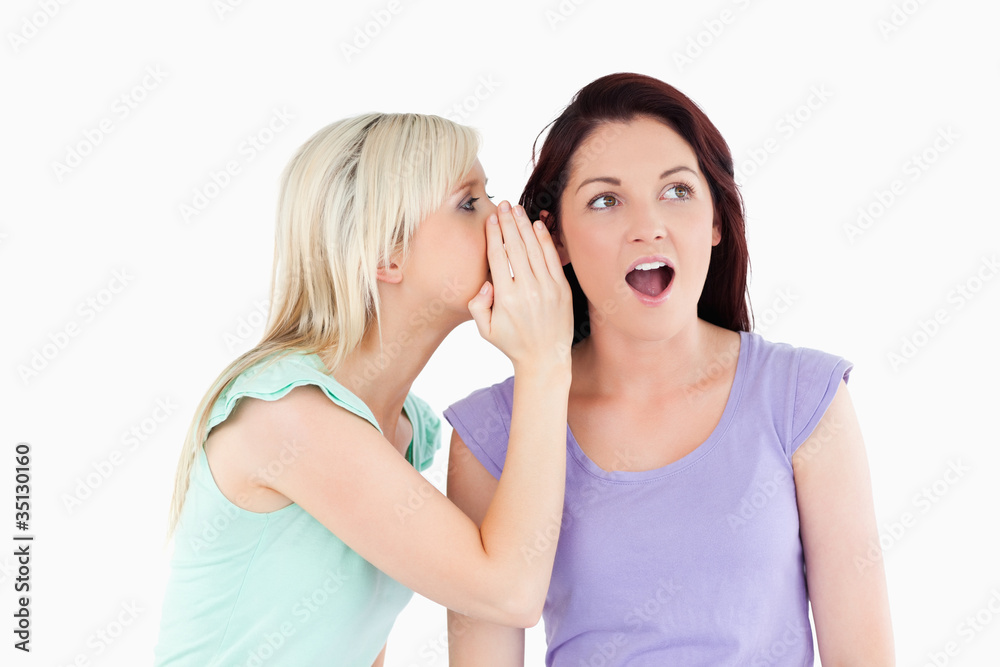 Portrait of a radiant woman telling her friend a secret Portrait of a radiant woman telling her friend a secret