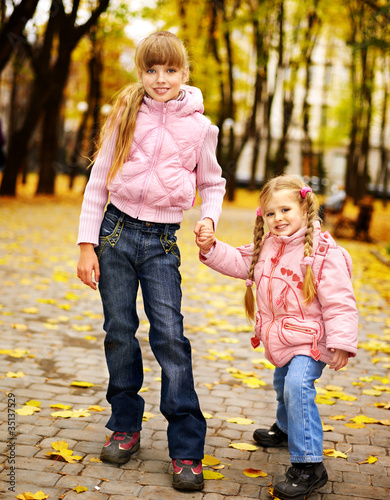 Kid in autumn orange leaves.