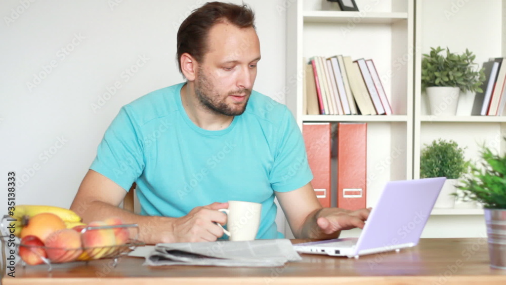 Portrait of young man drinking coffee working on laptop Portrait of young man drinking coffee working on laptop